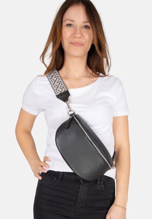 Black leather crossbody bag with a rounded shape, featuring a zip closure and a patterned adjustable strap in black and white.