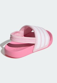 Rosa slide-sandal med en mjuk rem med vita ränder, texturerad sula och en dämpad fotbädd för komfort.