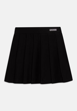 Jupe noire plissée avec une taille élastique sur laquelle est brodé le logo blanc "GUESS" à l'avant. Tissu lisse avec une coupe structurée.