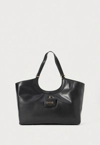 Fekete bőr bevásárlótáska sima textúrával, lekerekített fogantyúkkal és elől egy kis aranyozott díszítő táblával.