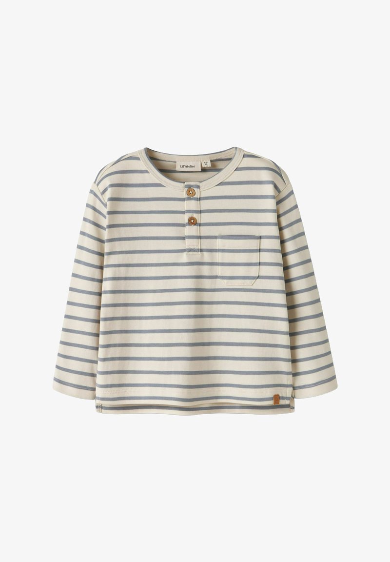 Pasiasta koszula z długim rękawem w kolorze kremowym z jasnoniebieskimi i granatowymi paskami. Posiada okrągły dekolt, pliskę z trzema guzikami oraz kieszeń na piersi.