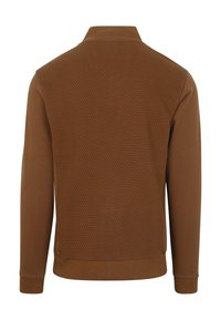 Bruine zip-up jas met een gestructureerd honingraatpatroon op de achterkant, een gladde stof aan de voorkant en strak aansluitende manchetten.