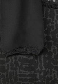 Zwarte kleding met een textuurstof in een subtiel patroon. Geribde manchetten en glad materiaal, wat het algehele slanke uiterlijk verbetert.