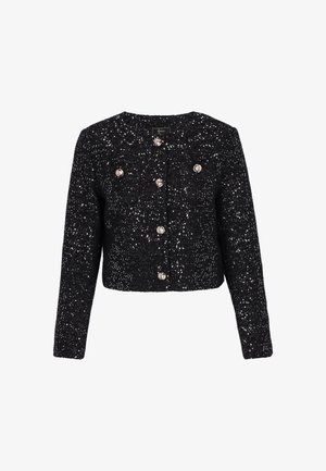 Černá kropenatá bunda s texturovaným povrchem, zdobená stříbrnými flitry a velkými kulatými knoflíky, s dlouhými rukávy a zaobleným výstřihem.