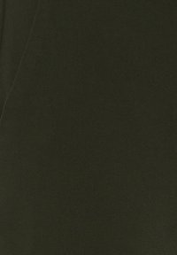 Tejido verde oscuro con una textura suave. El material parece resistente, mostrando un ligero brillo y sin patrones ni acentos visibles.
