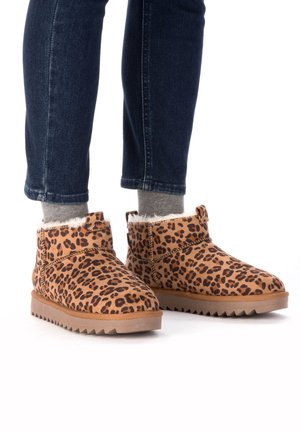 Leopard print ankle boots made of suede with a soft faux fur lining and a rugged rubber sole, featuring an adjustable side strap.