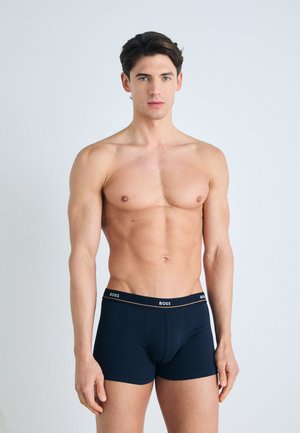 Marineblauwe herenslipboxers met een zachte textuur en een gemerkte tailleband. Het ontwerp heeft een aansluitende snit voor comfort en ondersteuning.