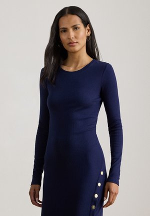 Marineblå langærmet kjole med tætsiddende pasform, rund halsudskæring og detaljer i form af guldbelagte knapper langs siden.