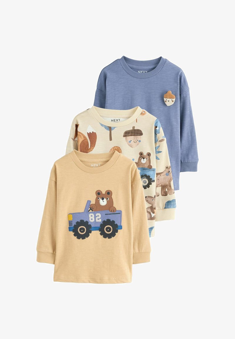 Tre børnebluser med lange ærmer, en blå med en agern-patch, en cremefarvet med skovdyrtryk og en beige med en bjørn, der kører en blå lastbil.