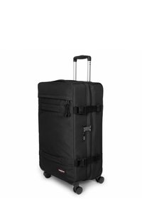 Maleta negra con ruedas hecha de tela resistente, que cuenta con un asa retráctil, compartimentos con cremallera y una correa resistente para mayor seguridad.