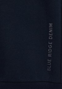 Navy blue sweatshirt made from soft fabric, featuring a ribbed hem and side detail with "BLUE RIDGE DENIM" in embossed text.