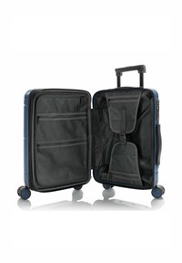 Hartschalenkoffer in Marineblau, mit einem schwarzen Innenfutter, das mehrere Netztaschen, ein Fach und einen ausziehbaren Griff mit Rädern enthält.