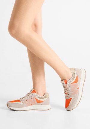 Baskets beige et orange avec mesh texturé et accents en cuir. Elles comportent une semelle rembourrée et une fermeture à lacets.