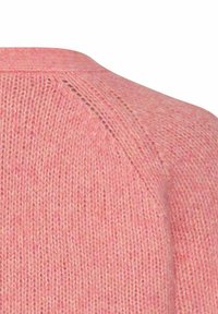 Sweter wykonany na drutach z miękkiej, jasnoróżowej tkaniny. Posiada okrągły dekolt i wyraźne przeszycia wzdłuż szwu na ramieniu.