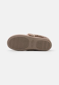 Lichtbruine slipperzool met een geprofileerde grip. Bevat een synthetisch materiaal met een zachte, bontachtige bovenkant en subtiele stikdetails.