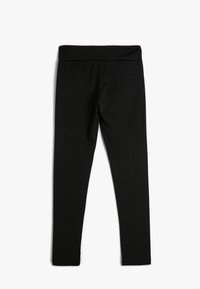 Sorte leggings lavet af strækbart materiale med en bred talje. De har en glat overflade og et tætsiddende design, der giver fuld dækning.
