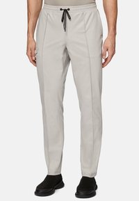 Light grey pants with an elastic waistband and black drawstring; featuring side pockets and a smooth, structured fabric texture.