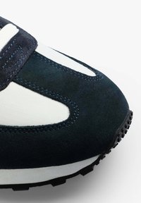 Sneaker in suede navy con accenti in tessuto bianco, caratterizzata da ritagli contornati, superficie testurizzata e suola in gomma nera con motivo di trazione.
