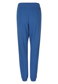 Blå sweatpants med en mjuk textur, avsmalnande ben och elastisk midja. Har sidostygn och en liten varumärkesetikett nära midjan.