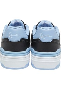 Pár černých a světle modrých tenisek zobrazených zezadu s polstrovanými límci a bílými podešvemi.