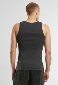 Graues ärmelloses Tanktop aus Baumwolle, mit rundem Halsausschnitt und taillierter Passform, von hinten gezeigt ohne auffällige Details.