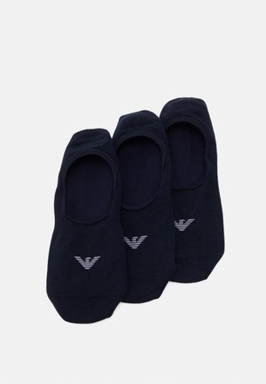 Chaussettes no-show noires, fabriquées en tissu doux, avec un design bas et un logo blanc sur le bout. Trois paires sont présentées.