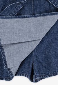 Denimshorts med en mørkeblå ytterfarge og en lysere innerforing, med synlige sømmer og lommedesign med klaff.