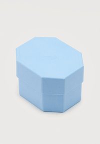 Φωτεινό γαλάζιο οκταγωνικό κουτί για κοσμήματα με υφή και διακριτικό ανάγλυφο σχέδιο στο καπάκι, τοποθετημένο πάνω σε απλό λευκό φόντο.