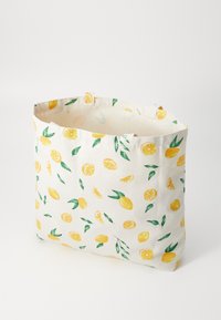 Canvas tote bag with yellow lemon and green leaf print, standing open on white background.