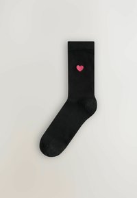 Schwarze Baumwollsocke mit glatter Textur, versehen mit einer kleinen rosa Herzstickerei nahe der Oberseite. Klassische Form mit runder Spitze.