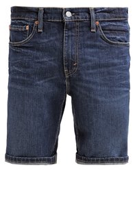 Tummansiniset farkkushortsit klassisella viiden taskun muotoilulla, jossa on nappikiinnitys, oranssit ompeleet ja käännetyt lahkeensuukkeet.