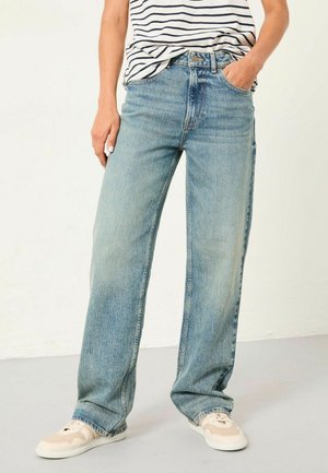 Light blue wide-leg jeans made of denim, featuring a high waist, five pockets, and subtle fading. Paired with cream sneakers.