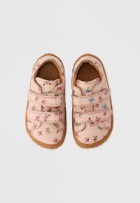 Chaussures synthétiques roses avec motif floral, dotées de deux bandes Velcro et d'une semelle en caoutchouc texturée pour l'adhérence, conçues pour le confort et le soutien.