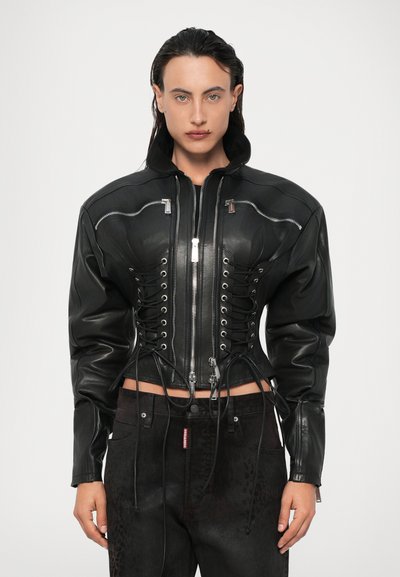 Veste en cuir noir au design ajusté, avec un zip à l'avant, des détails à lacets sur les côtés et des poches zippées. Finition texturée.
