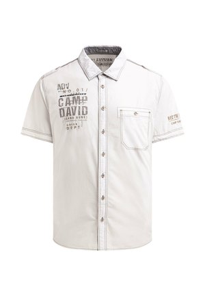 Beiges Hemd mit kurzen Ärmeln zum Knöpfen, mit Brusttasche und dem aufgedruckten Text „CAMP DAVIG“ auf der linken Brust und „REGTM“ auf dem rechten Ärmel.