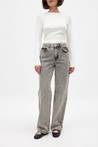 Valkoinen pitkähihainen paita yhdistettynä harmaisiin korkeavyötäröisiin farkkuihin, joissa on haalistunut pesu ja suora lahje, ja asusteena mustat ballerinat.