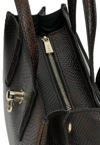 Zwarte, gestructureerde handtas met een textuur en een duidelijke vorm, voorzien van een gouden ritssluiting en metalen accenten, ontworpen met een reptielmotief en dubbele handvatten.