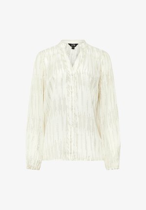 Kreemivärvi pikkade varrukatega pluus, millel on vertikaalsed metallilised triibud, nööpidega esiosa ja kootud mansetid. Sile kangas, millel on peen sära ja tekstuurilised detailid.