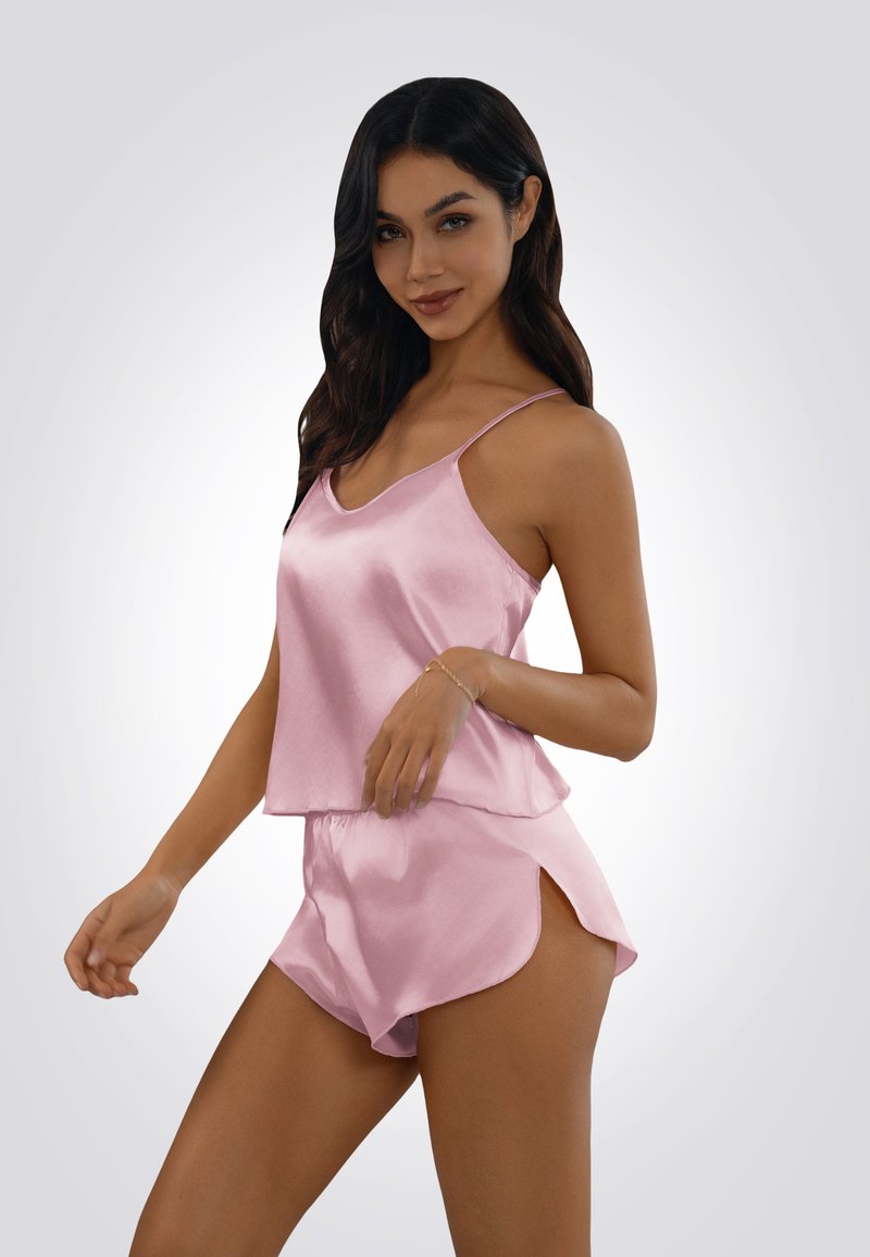 Ensemble de nuit en satin rose pâle comprenant un haut sans manches avec un col en V et un short assorti avec un ourlet arrondi et des fentes sur les côtés pour le confort.
