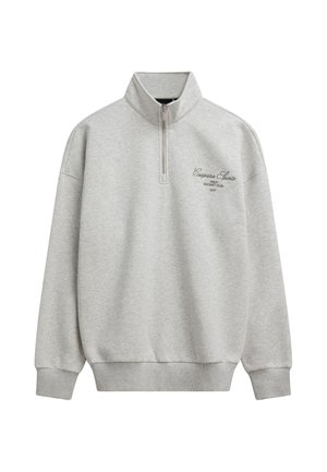 Lysegrå sweatshirt med kvartlynlås, ribmanchetter og -kant, høj krave og lille sort tekstlogo på venstre bryst.