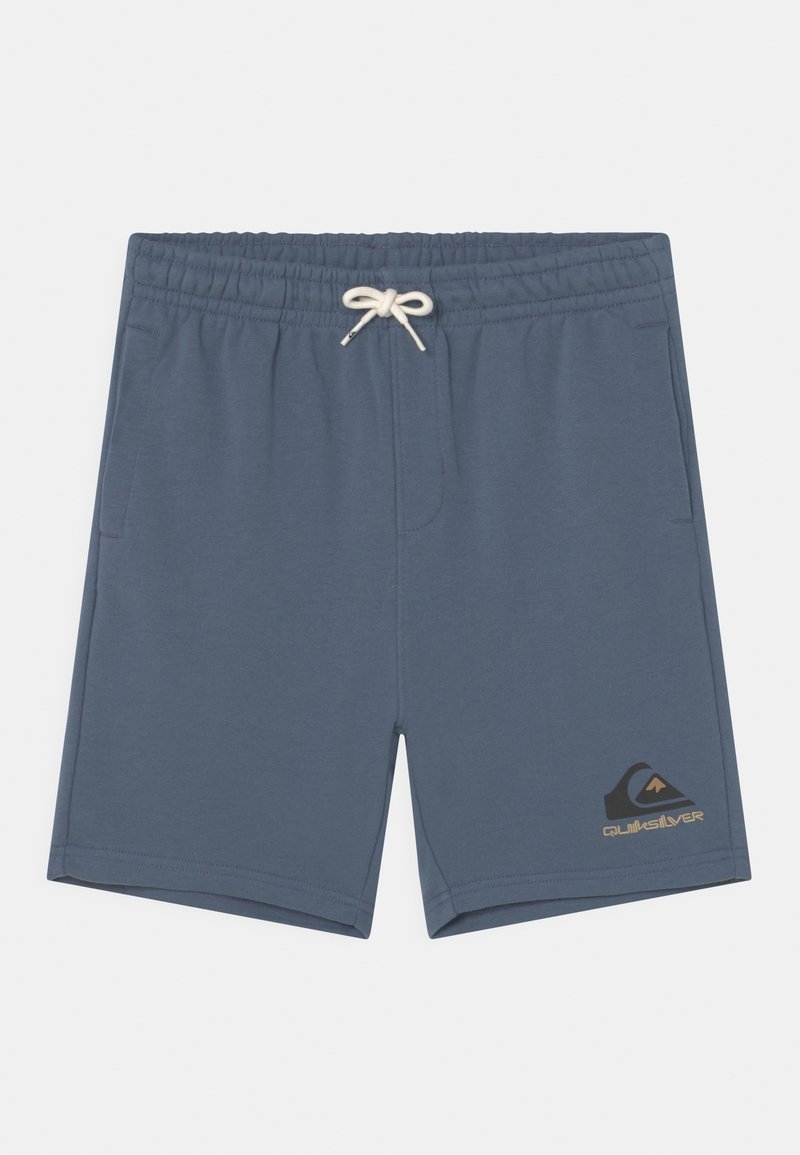 Shorts bleu avec taille élastique et cordon de serrage blanc, poches latérales, avec un logo Quiksilver noir et beige sur l'ourlet de la jambe gauche.