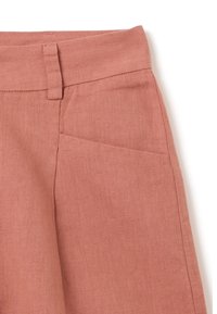 Pantalons en lin beige rosé avec une taille plate, des poches latérales et un tissu texturé. Le tissu présente une variation subtile et naturelle de ton.