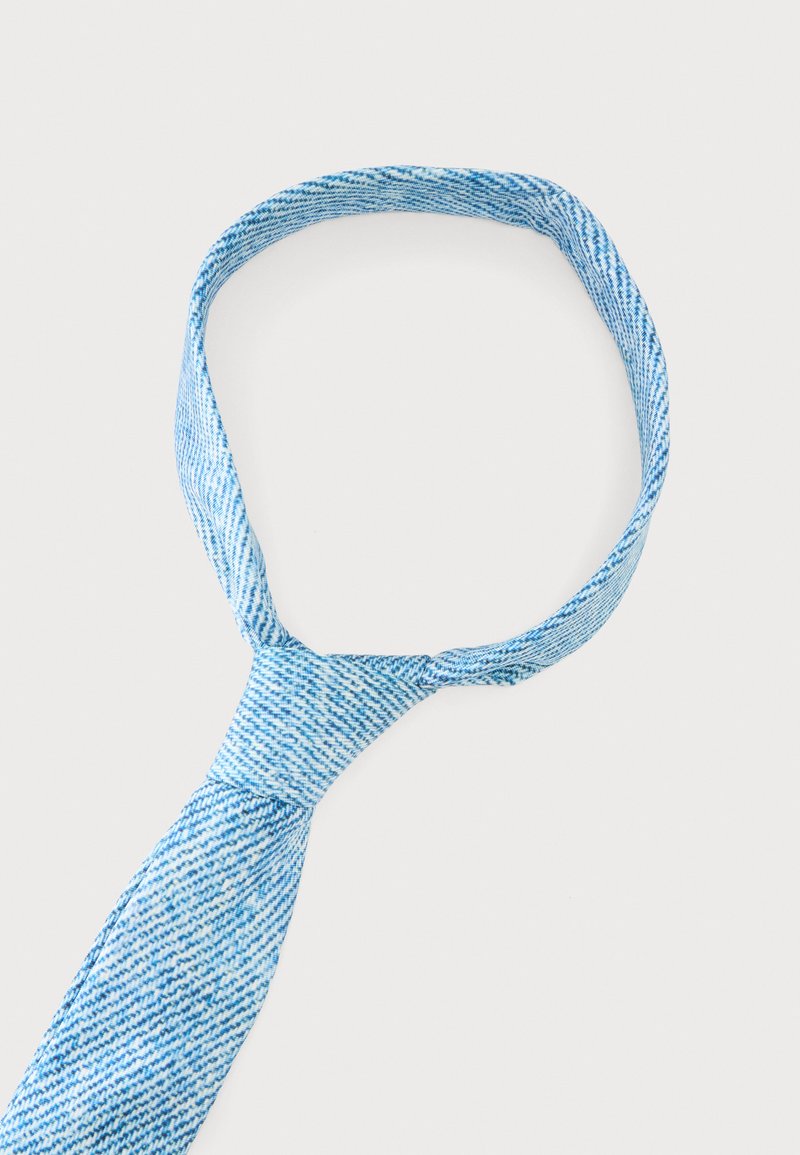 Corbata texturizada azul y blanca anudada con un nudo y un lazo sobre un fondo blanco.