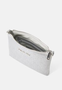 Clutch in pelle argento con motivo a logo embossato, chiusura con zip e foderatura beige. Presenta scomparti interni e una zip in metallo argentato.