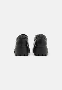 Zwarte lederen schoenen met een gladde afwerking, ronde neus en een stevige, gedetailleerde zool. Voorzien van zichtbare stiksels en metalen accenten.