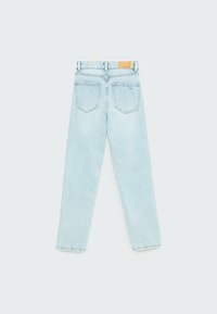 Ljusblå denimjeans med rak bendesign, fem fickor och en läderlapp på den bakre midjebanden. Avblekt textur och sömnadsdetaljer.