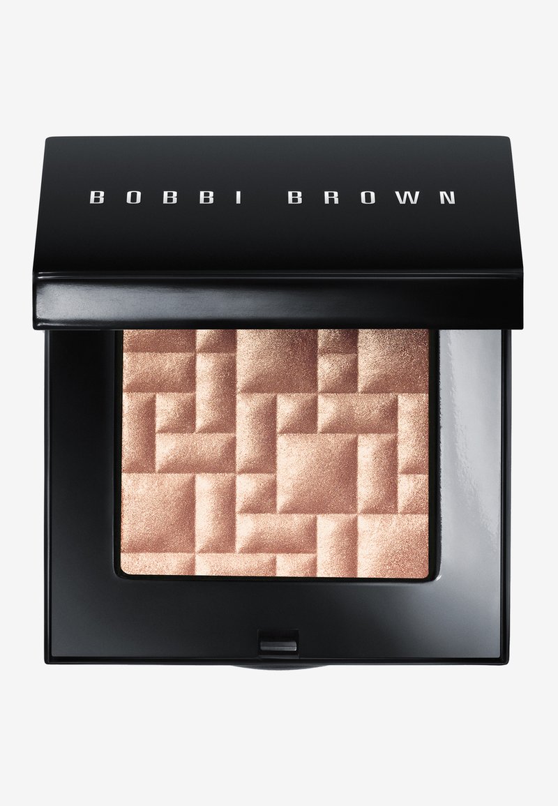 Compact Bobbi Brown avec un extérieur noir brillant, présentant une surface en poudre rose doré texturée dans un motif géométrique.