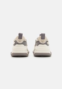 Beige and gray athletic shoes made of mesh and suede; features pull tabs, a chunky sole, and a textured design. Rear view shown.