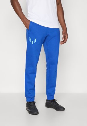 Blue sweatpants made of soft fabric, featuring side pockets and a light blue graphic logo on the left thigh. Elastic cuffs at the ankles.
