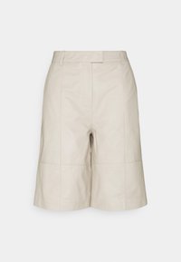 Pantaloni corti in pelle beige con una vestibilità sartoriale, caratterizzati da cuciture frontali e una superficie liscia. Progettati con vita media e tasche laterali.